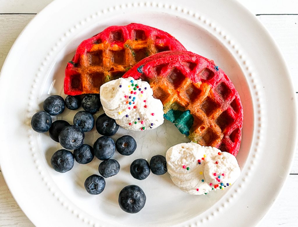 Rainbow Waffles Blueberries Whipped Cream on a plate